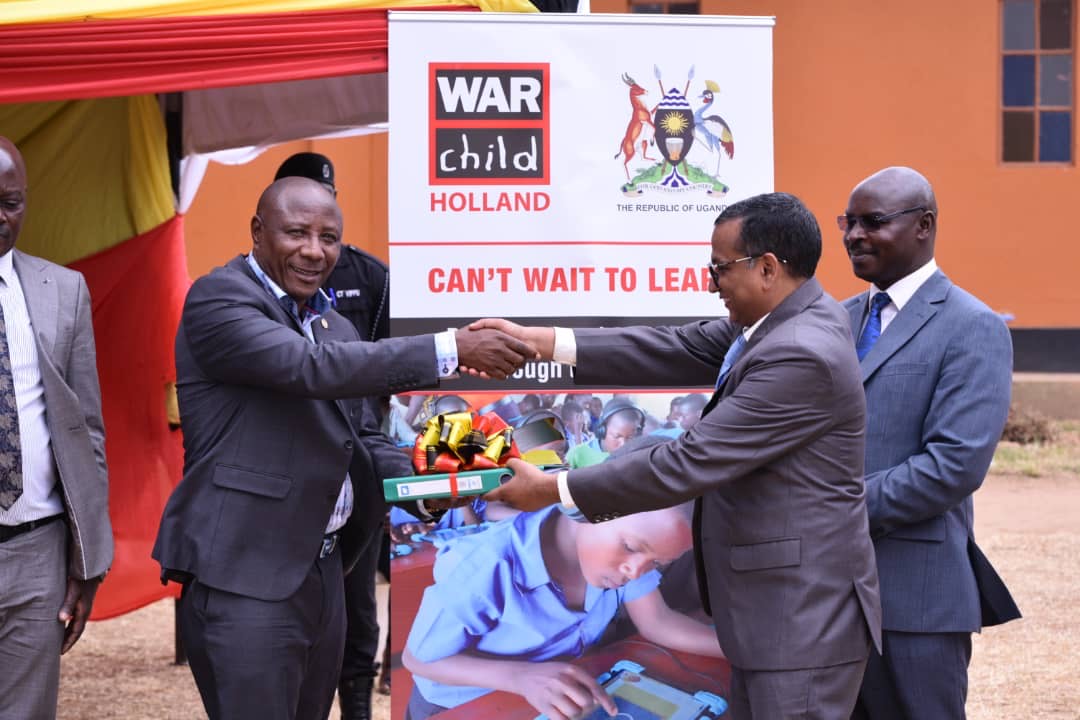 State Minister for National Guidance Godfrey Kabyanga receives the pilot study report from Perwez Anis, the deputy country director of War Child Holland